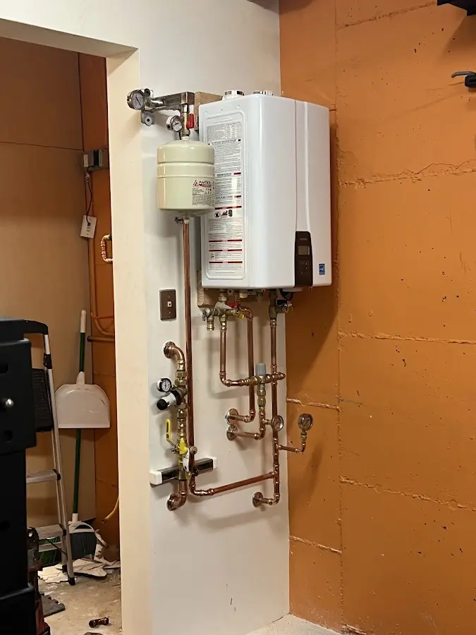 Plumbing technician inspecting water heater connections in Millvale